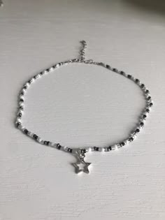 Black and white beaded choker with silver star charm. Necklace length can be adjusted from 12.5-n-15.5in. If you would like the choker to be longer, please message me. Beads are czech glass size 10/0 seed beads. Super cute and lightweight. Necklace care: avoid wearing in water or to sleep to keep necklace in the best shape. Store in a cool, dry place. Overtime, the clasp and chain may begin tarnish. Star Charm Choker, White Crystal Beaded Necklace, Star Girl Necklace, Silver Star Choker, Beaded Black Necklace, Aesthetic Choker Necklace, Cute Necklaces To Make With Beads, White Necklace Beads, Aesthetic Bead Necklaces