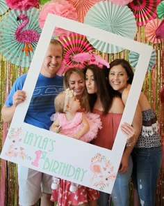 a family posing for a photo in front of a birthday backdrop