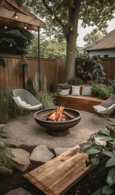 an outdoor fire pit surrounded by chairs and trees