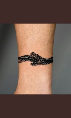 a black and white snake tattoo on the ankle