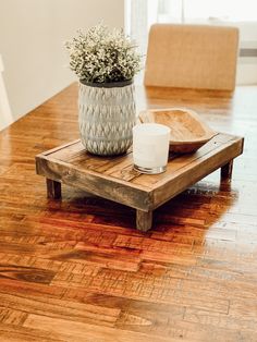 a wooden table with a plant and a plate on it