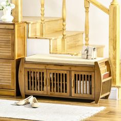 a wooden bench sitting on top of a hard wood floor next to a stair case