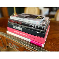 a stack of books sitting on top of a wooden table