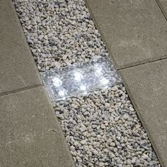 a close up of a street sign on the ground with rocks and gravel around it