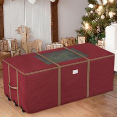 a christmas tree with presents in front of it and a red box on the floor