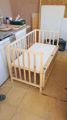 a baby crib sitting in the middle of a kitchen