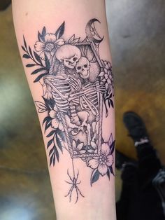 a black and white photo of a skeleton with flowers on it's arm