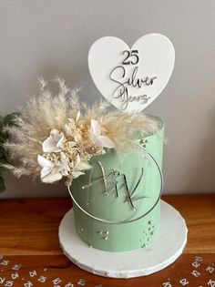 a cake decorated with feathers and flowers on a table