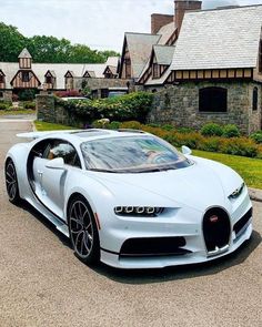 a white bugatti parked in front of a house