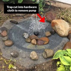 a garden pond with rocks and water coming out of it