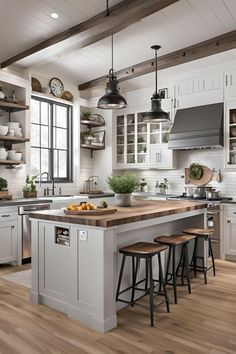 a large kitchen with white cabinets and wooden counter tops, along with two stools