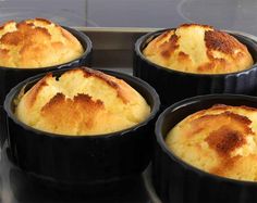 four black pans filled with food sitting on top of a stove