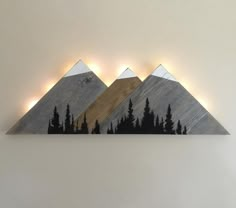 three mountains are shown with lights on the top and bottom one is made out of wood