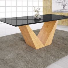 a black glass table with wooden legs in a living room setting on carpeted flooring