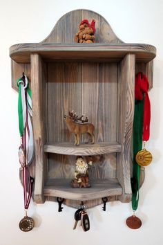 a wooden shelf with medals and other items on it's sides, hanging from the wall