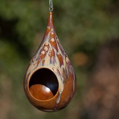 a wooden bird feeder hanging from a chain