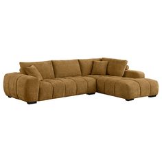 a brown sectional couch with pillows on it's back and arm rests against the wall