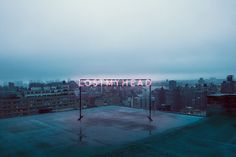 a neon sign that reads don't tread on top of a building