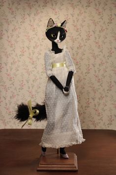 a black and white cat dressed up as a woman