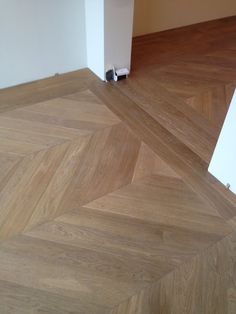 an empty room with hard wood floors and white walls, in the middle of a parquet floor