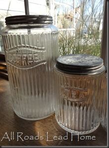 three glass jars sitting next to each other on a window sill in front of a window