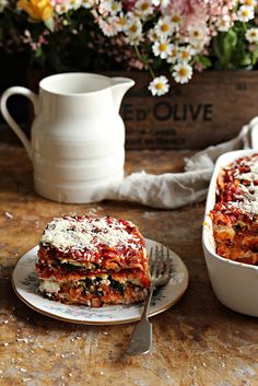 lasagna casserole on a plate with a fork next to the casserole