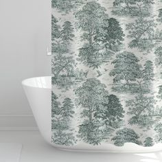 a shower curtain with trees on it and a white bathtub in the foreground