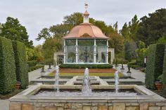 a gazebo in the middle of a garden with fountains