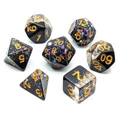 six black and gold dice with numbers on them, all in different shapes and sizes