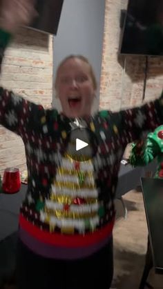 a woman in a ugly sweater is dancing with her arms up and hands out to the side