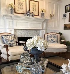 a living room filled with furniture and a fire place covered in white hydrangeas