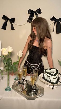 a woman standing in front of a table with cake and champagne glasses on top of it