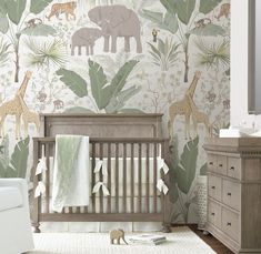 a baby's room with an elephant and giraffe wallpaper on the walls