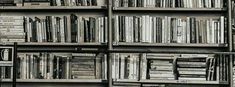 an old book shelf filled with lots of books next to a wall full of books