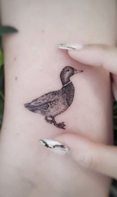 a small bird tattoo on the side of a woman's right arm