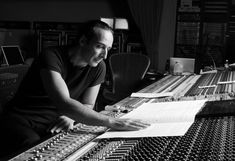 a man sitting in front of a mixing desk