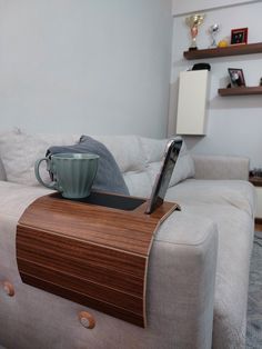 a coffee cup sitting on top of a wooden table next to a white couch in a living room