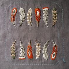 several different types of feathers laid out on a piece of cloth with stitching in the middle