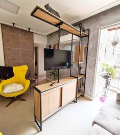 a living room filled with furniture and a flat screen tv on top of a wooden cabinet