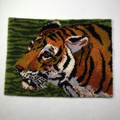 a close up of a rug with a tiger on it's face and green stripes