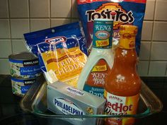 an assortment of condiments and drinks on a glass shelf in a kitchen area