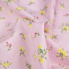 a pink fabric with yellow and red flowers on it