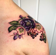 a woman's shoulder with flowers and berries tattooed on her left side breast area