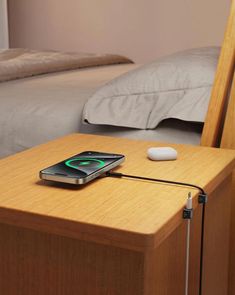 a cell phone sitting on top of a wooden table next to a laptop and mouse