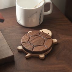 a wooden turtle coaster next to a coffee mug