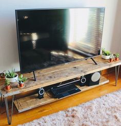 a flat screen tv sitting on top of a wooden stand