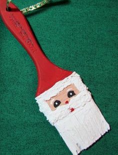 a toothbrush with a santa clause on it sitting on a green surface next to scissors