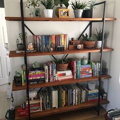 a bookshelf filled with lots of books and plants