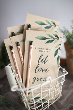 some pencils are sitting in a basket next to two notebooks that say let love grow