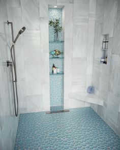 a bathroom with blue and white tiles on the floor, shower stall and shelves in the wall